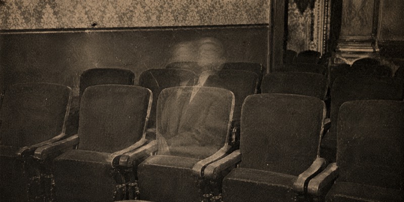 Empty theatre seats after the interval, one faintly occupied